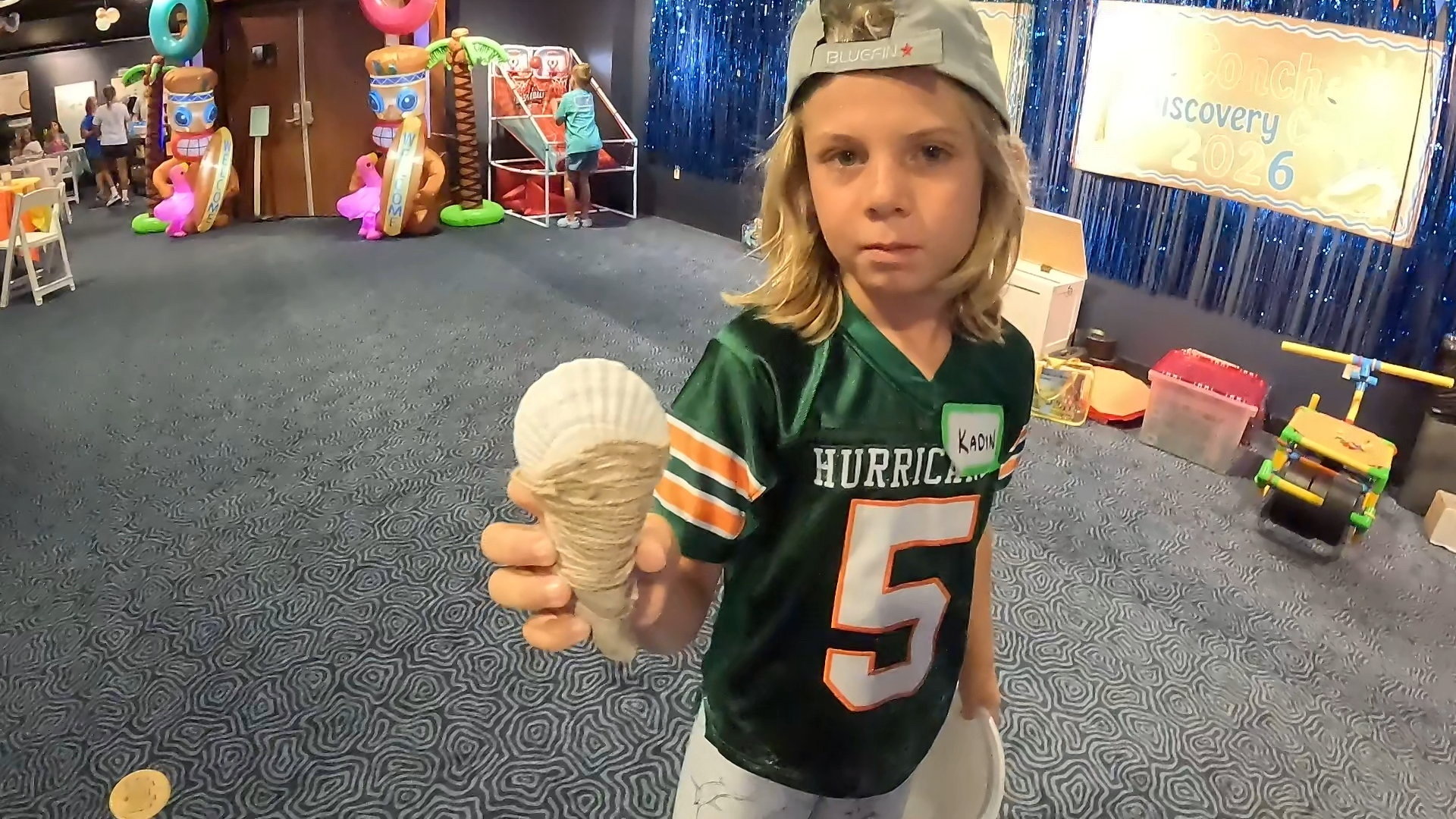 A camper proudly displays a shell wrapped in twine