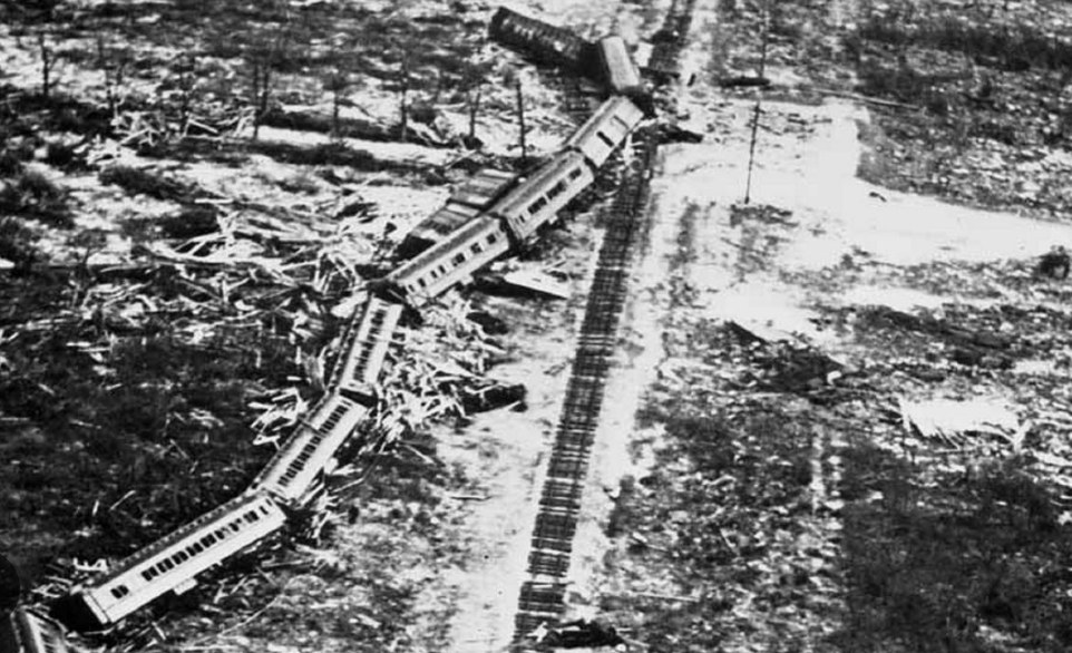 Aerial photograph of derailed passenger cars scattered beside a stretch of track after the 1935 Labor Day Hurricane.