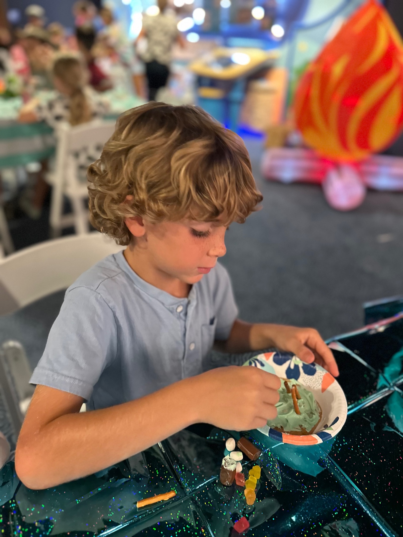 A camper concentrates on decorating a treat