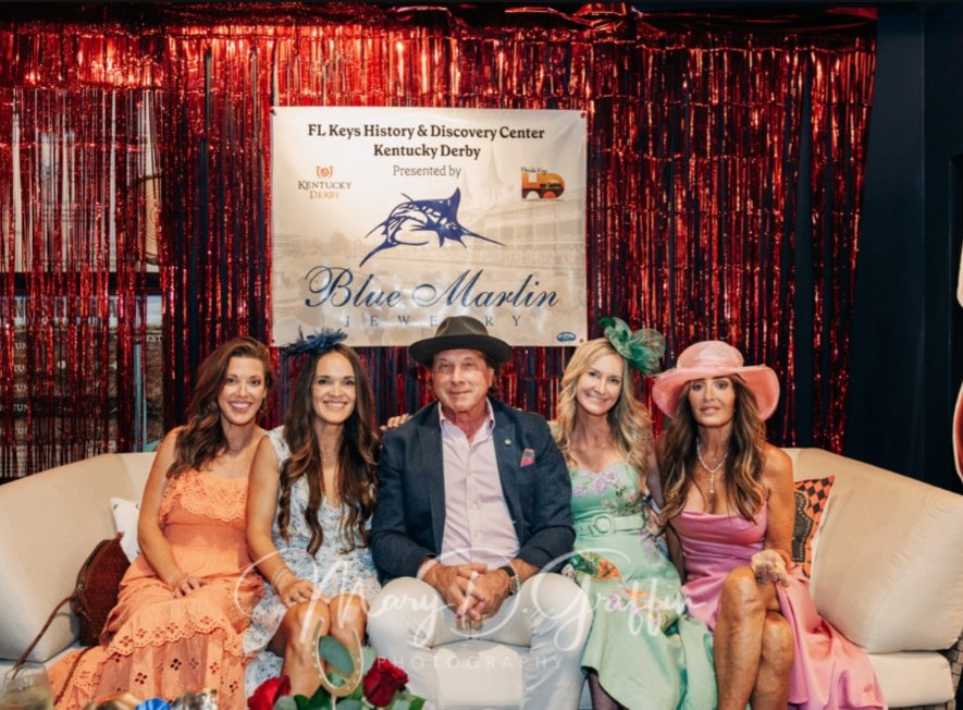 Guests pose on a sofa beneath the Center's Kentucky Derby banner