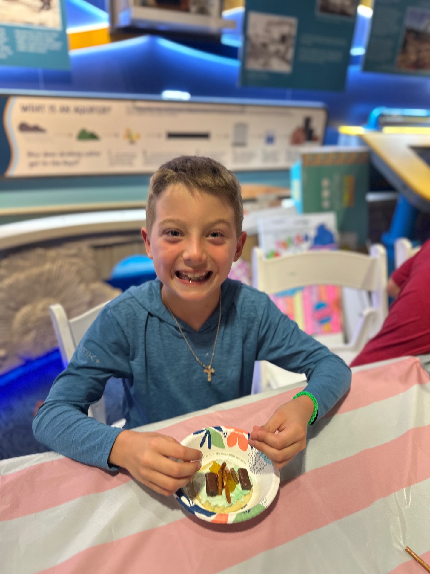 A smiling camper with his edible creation in the exhibit hall