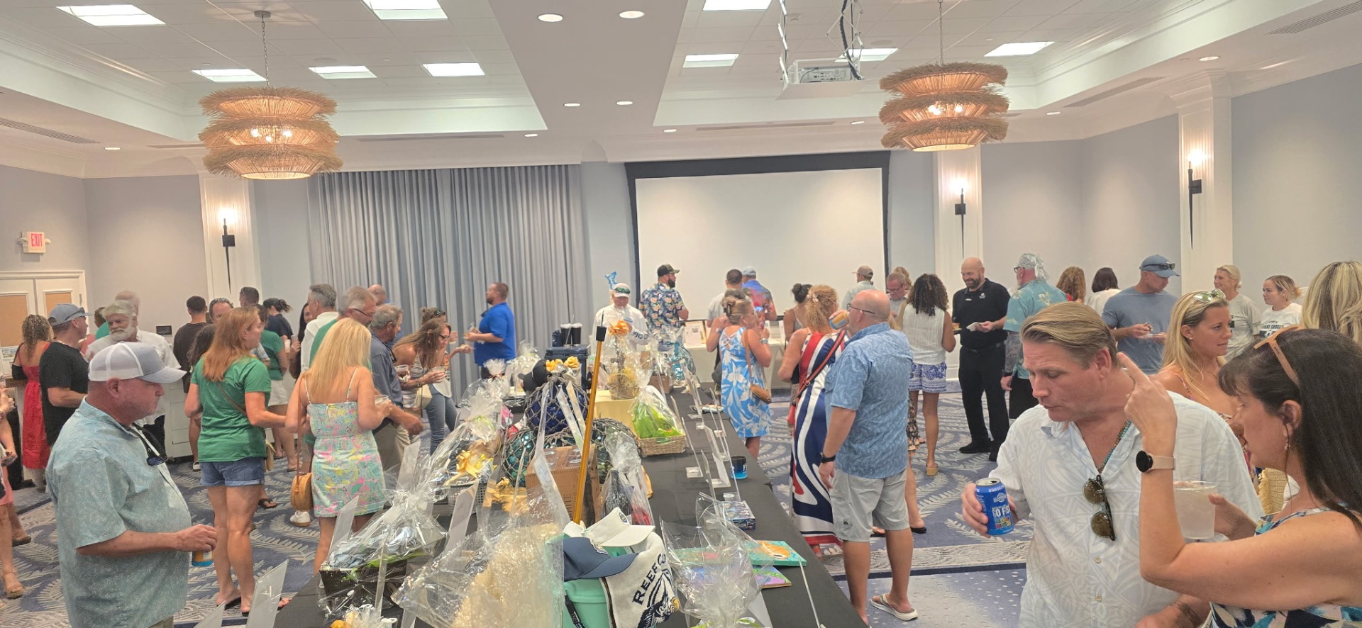 A crowd browses raffle baskets and silent auction tables at the Conch Scramble kickoff party