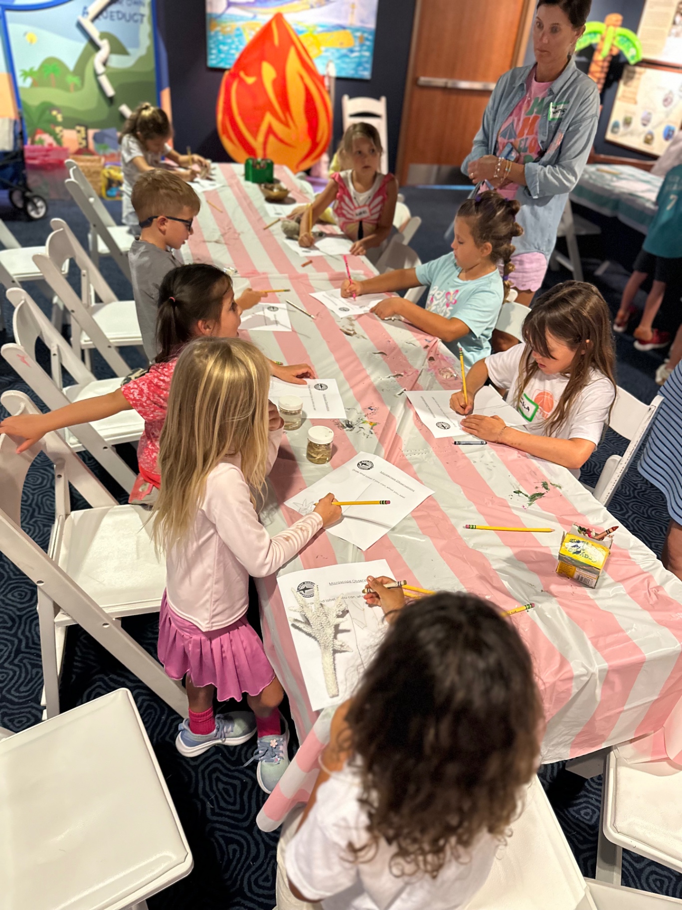 Campers sketching and labeling specimens at a long activity table