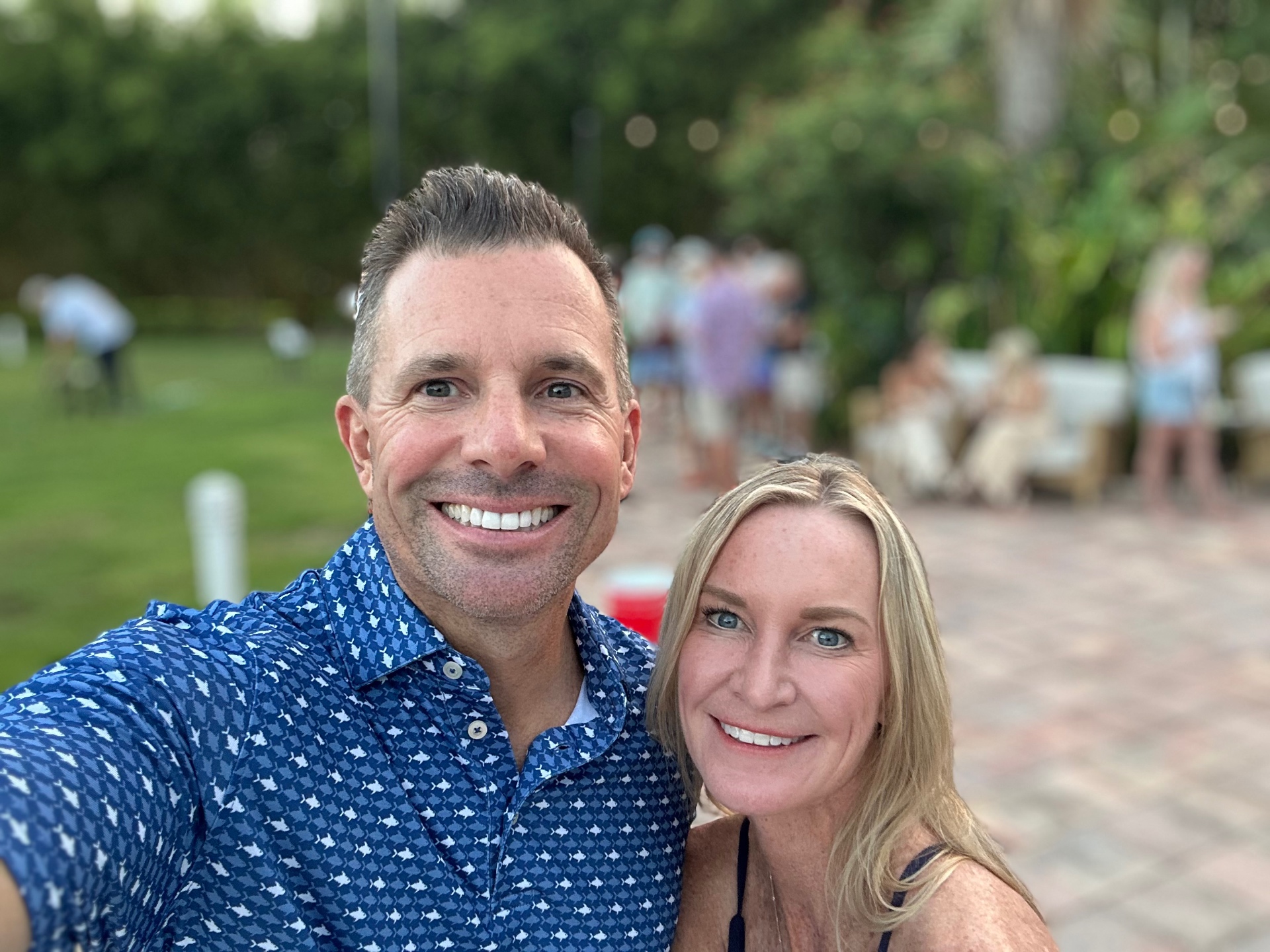 Guests smile together at the Conch Scramble kickoff party on an evening lawn