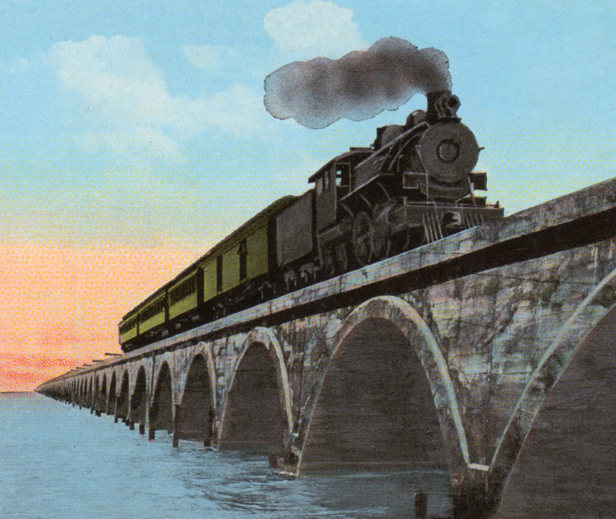Colorized photograph of a steam locomotive pulling passenger cars across the concrete arch viaduct of Flagler's Overseas Railroad as the sun sets over the water