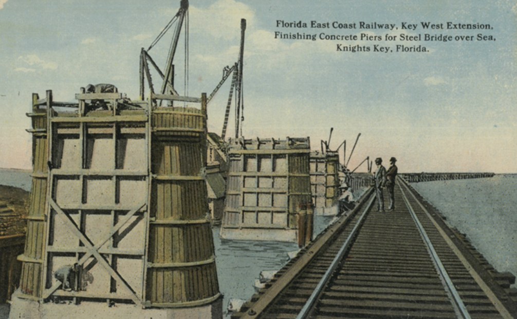 Historic postcard of workers finishing concrete piers for the steel bridge over the sea at Knights Key.