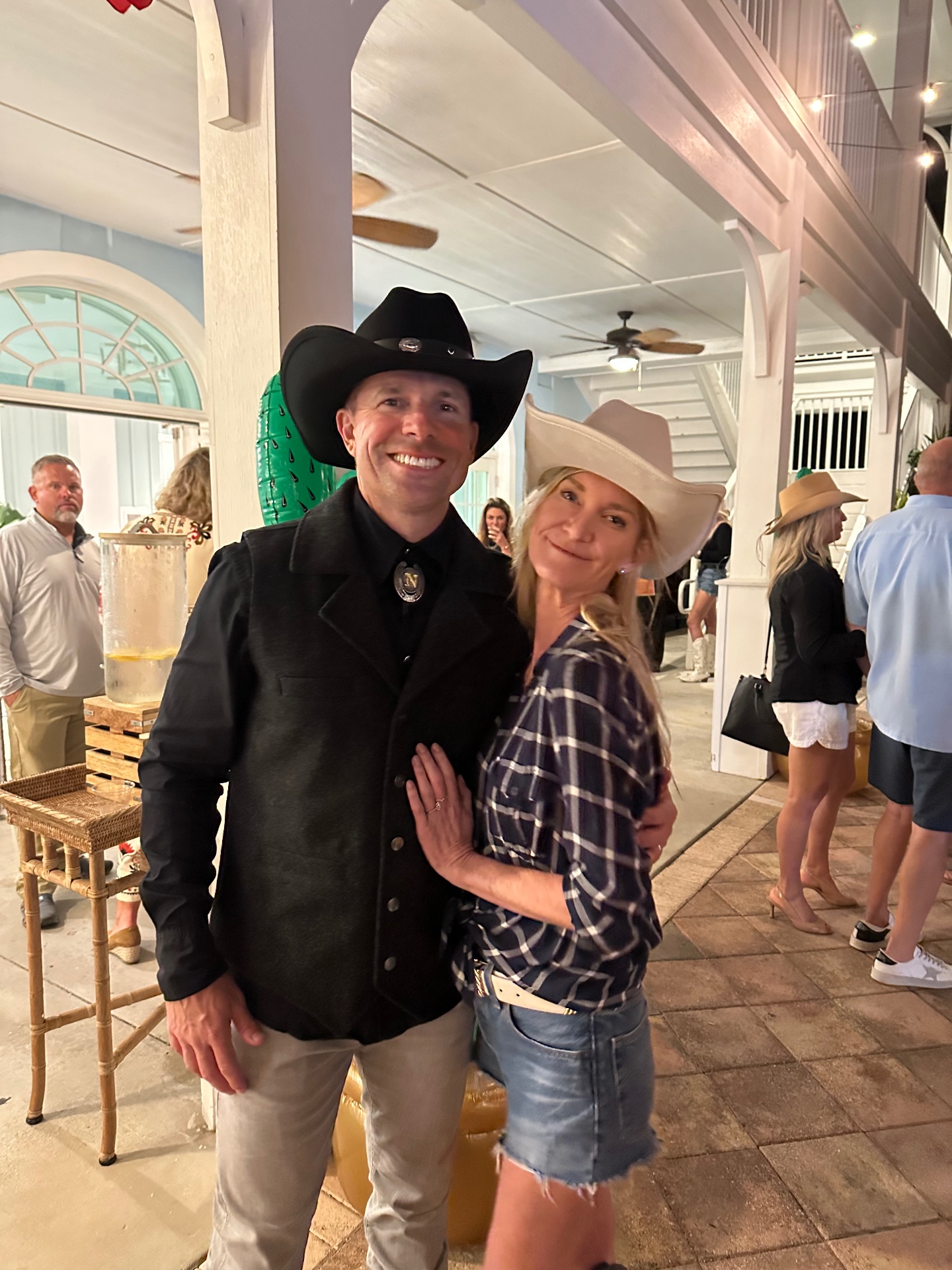 Two guests in cowboy hats pose together at the Hoedown fundraiser