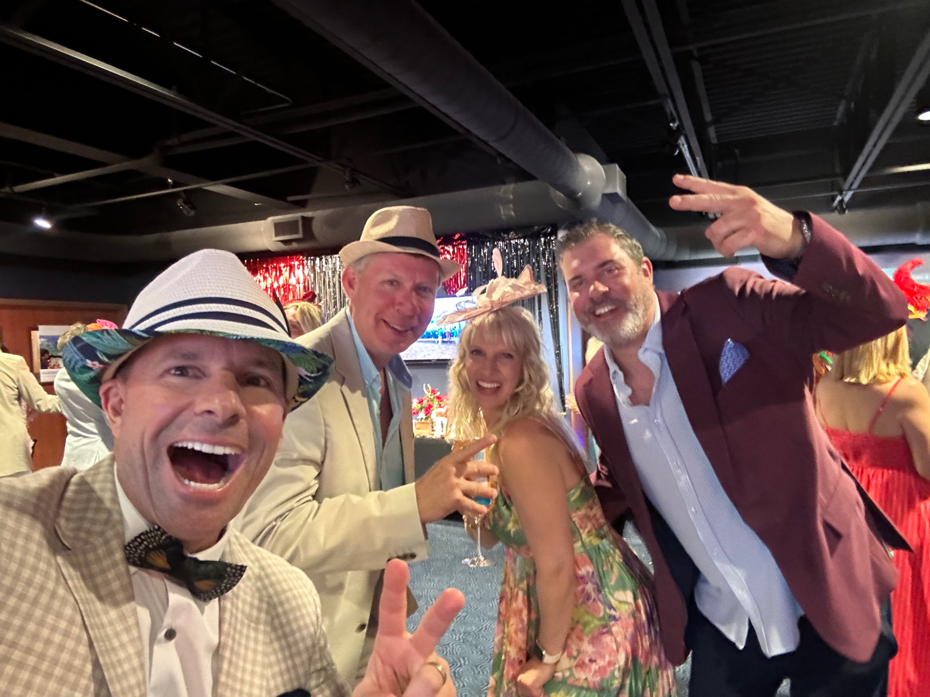 A group of party guests in festive hats take a selfie together