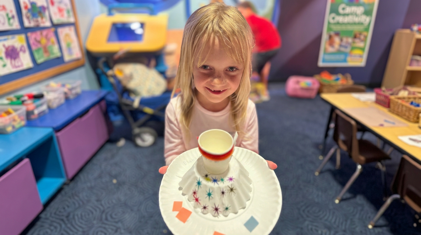 A camper holds up her decorated jellyfish craft