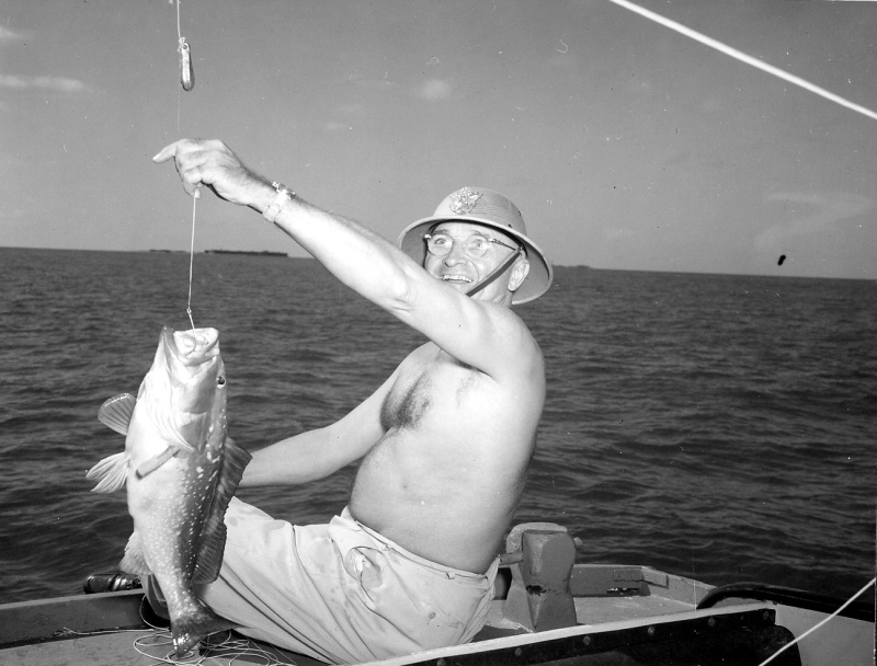 President Truman in a boat off Key West in 1946, holding up a grouper on his line