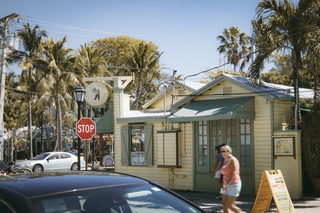 A lively Key West street scene with palm trees and a quaint restaurant