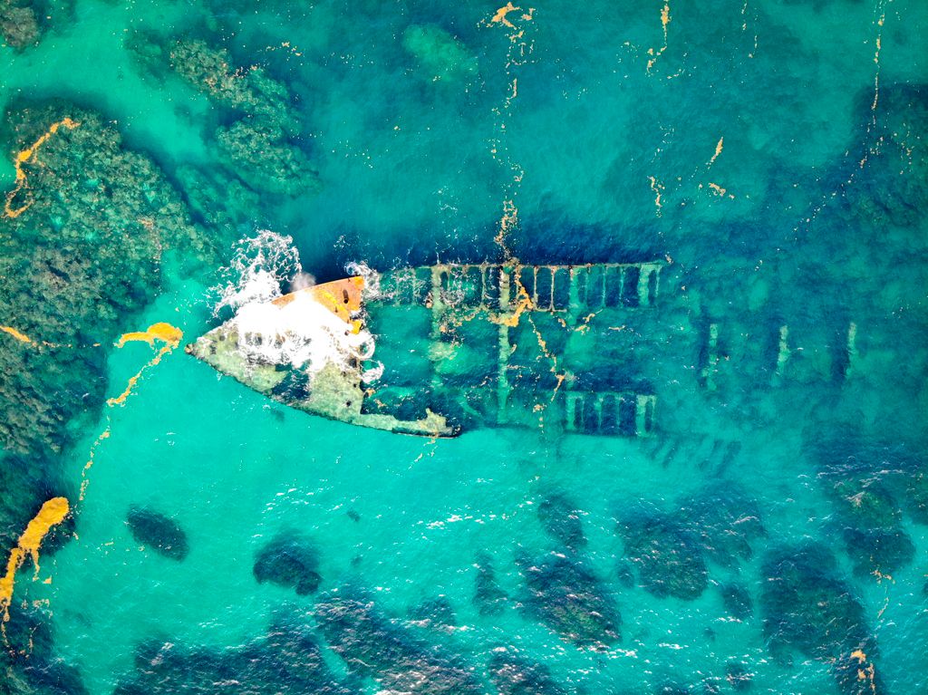Aerial view of an abandoned shipwreck beneath turquoise water in the Florida Keys